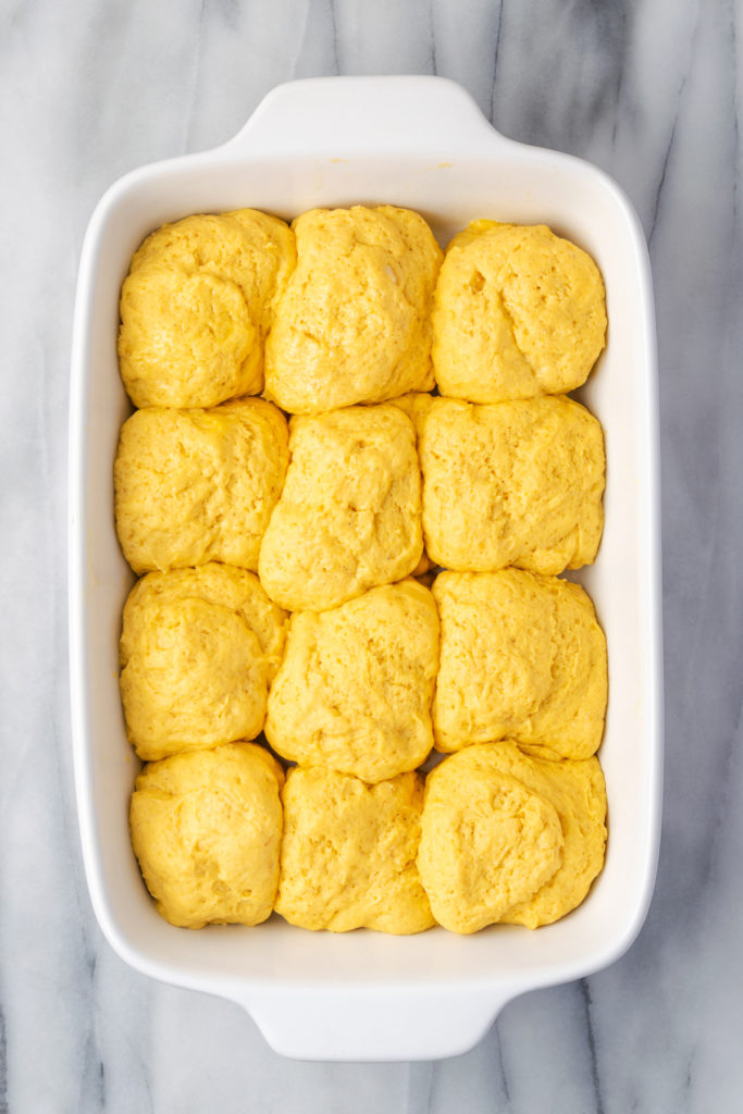 Overhead view of unbaked sweet potato rolls in baking dish