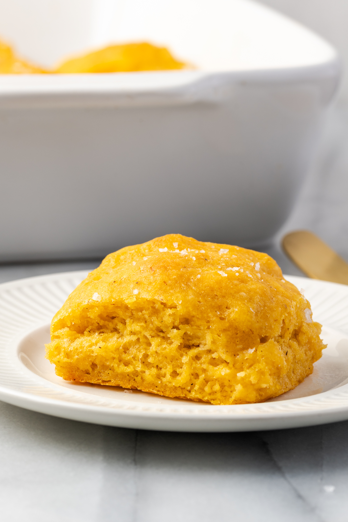 Side view of fluffy sweet potato roll on white plate