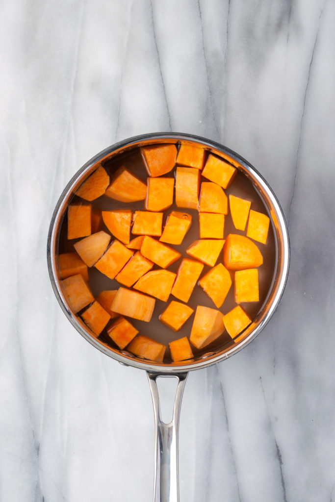 Overhead view of sweet potatoes in pot of water