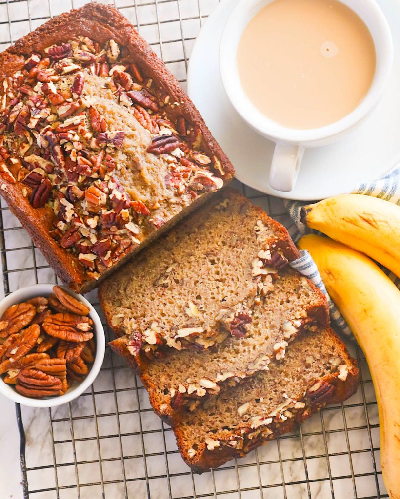 Decadent banana bread with nuts and a steaming cup of coffee