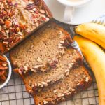 Decadent banana bread with nuts and a steaming cup of coffee