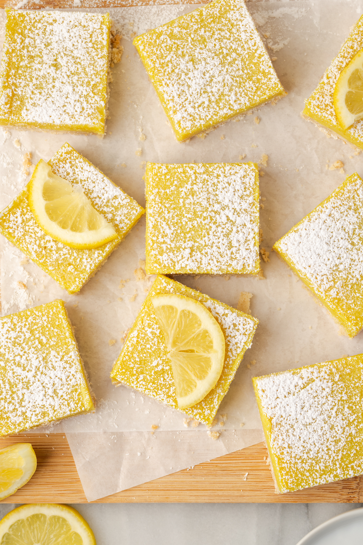 Overhead view of vegan lemon bars on parchment-lined board