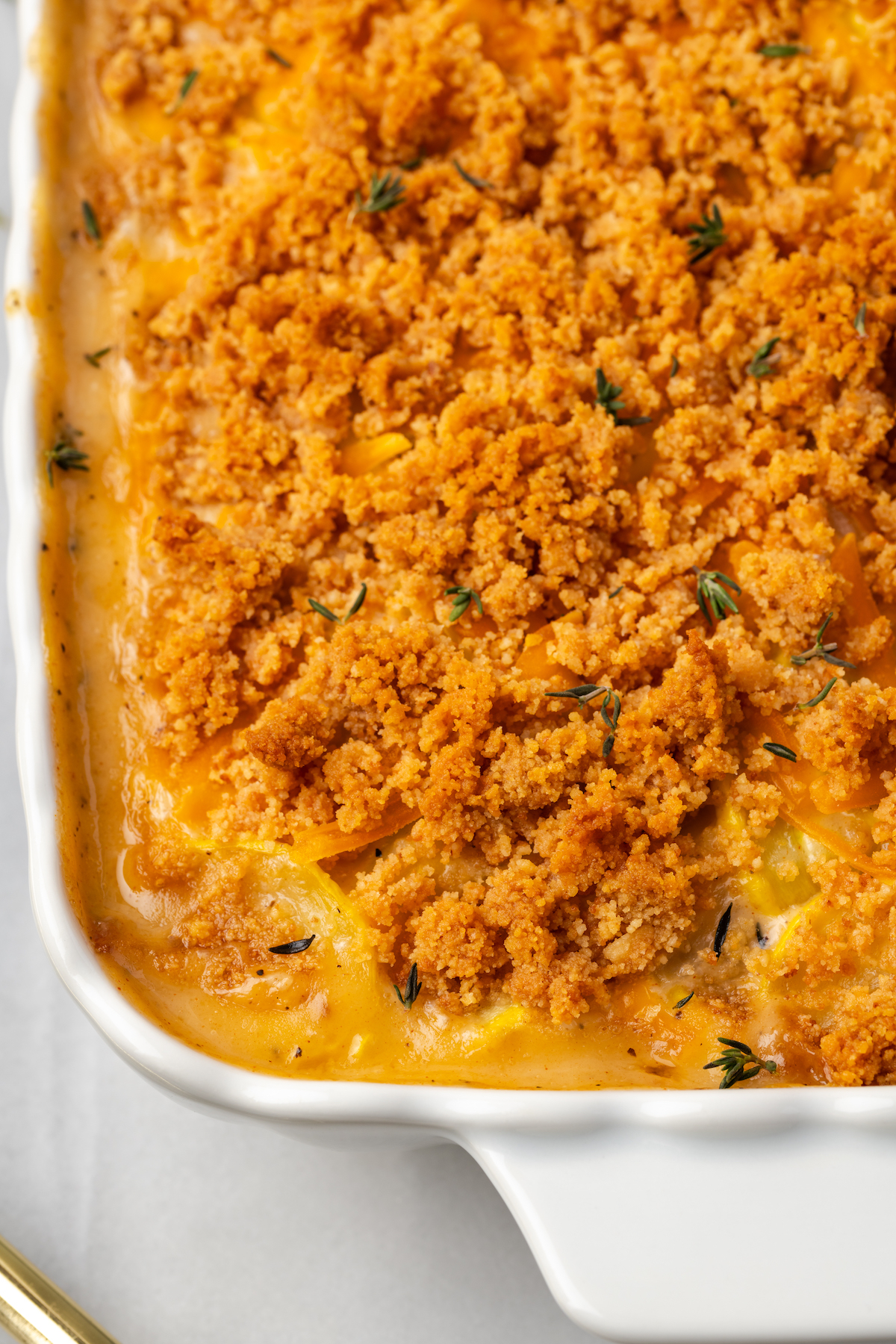 Top-down view of squash casserole in baking dish with breadcrumb topping