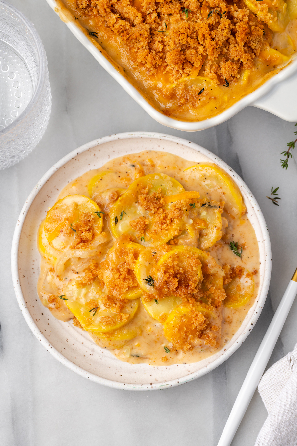 Overhead view of squash casserole on plate and in casserole dish