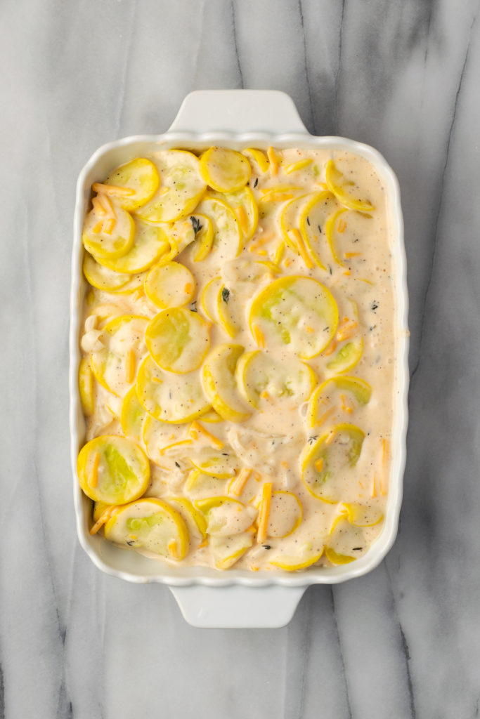 Overhead view of squash casserole filling in baking dish